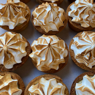 Twelve mini Lemon Meringue tarts with golden-brown toasted meringue swirls on buttery crusts, arranged in a close-up grid