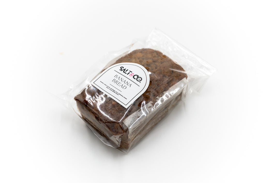 A packaged loaf of peanut butter banana bread from Salt & Co, neatly wrapped in clear plastic with a label displaying the brand's logo and product name. The bread's moist and rich texture is visible through the packaging, making it an appealing choice for customers seeking a tasty, ready-to-eat treat.