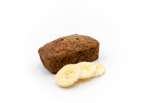 Load image into Gallery viewer, A delicious mini peanut butter banana bread topped with fresh banana slices, on a white background. The image showcases the moist texture and rich color of the banana bread, highlighting its homemade appeal. Perfect for a bakery&#39;s promotional content
