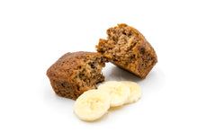 Load image into Gallery viewer, A close-up shot of a halved banana bread with a moist, fluffy interior, placed alongside fresh banana slices. The image highlights the rich texture and tempting appearance of the muffin, making it an inviting treat for banana bread lovers. Perfect for showcasing the product&#39;s quality and freshness.
