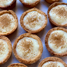 Load image into Gallery viewer, Close-up of 12 mini milk tarts with golden shortcrust pastry, topped with a light sprinkle of cinnamon, arranged neatly n a box
