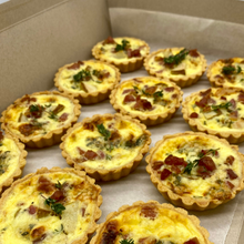 Load image into Gallery viewer, Twelve mini quiches in a box, featuring a mix of bacon and fresh herbs, perfect for sharing
